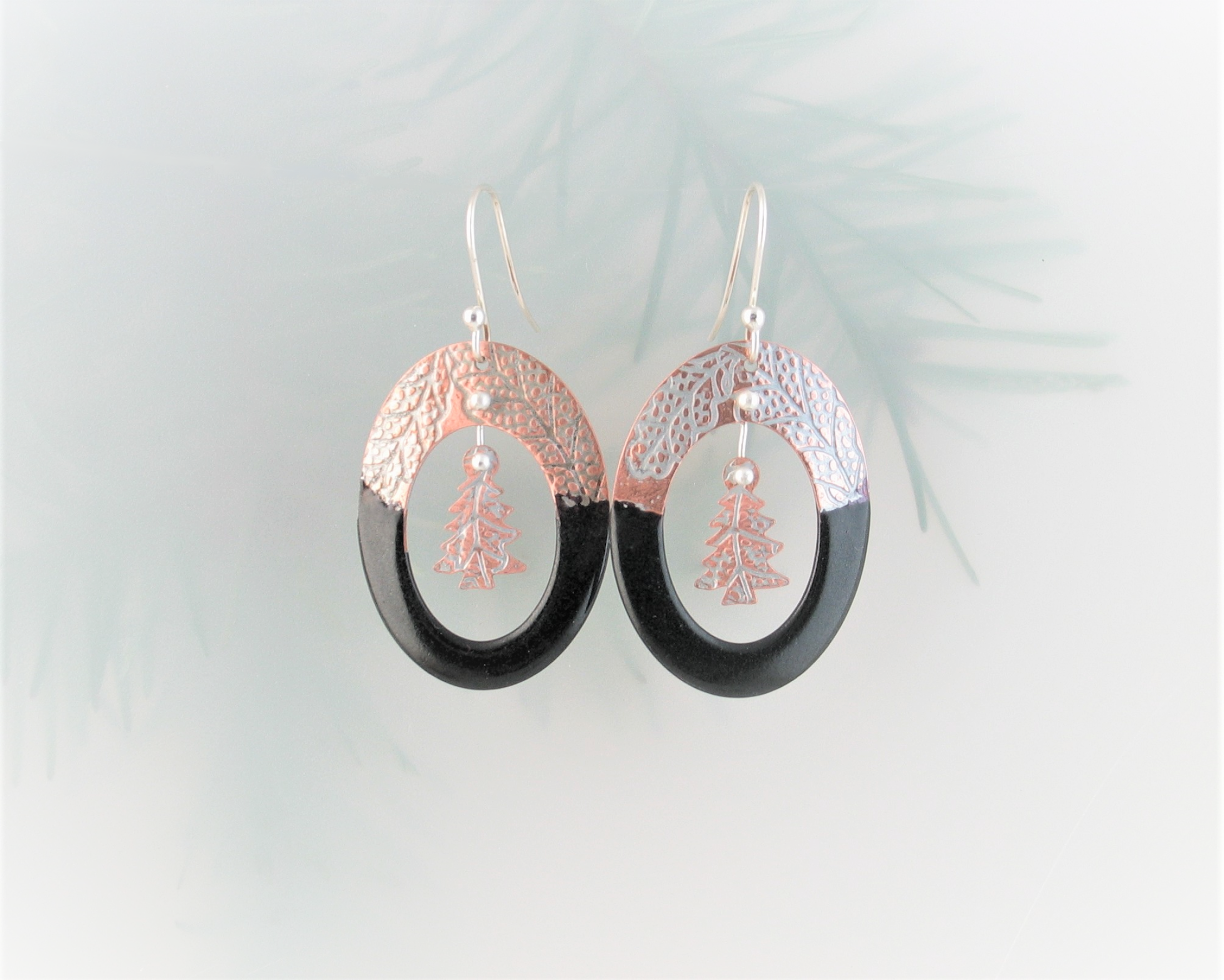 Black copper enamel hoop earrings with dangling tree inside hoop